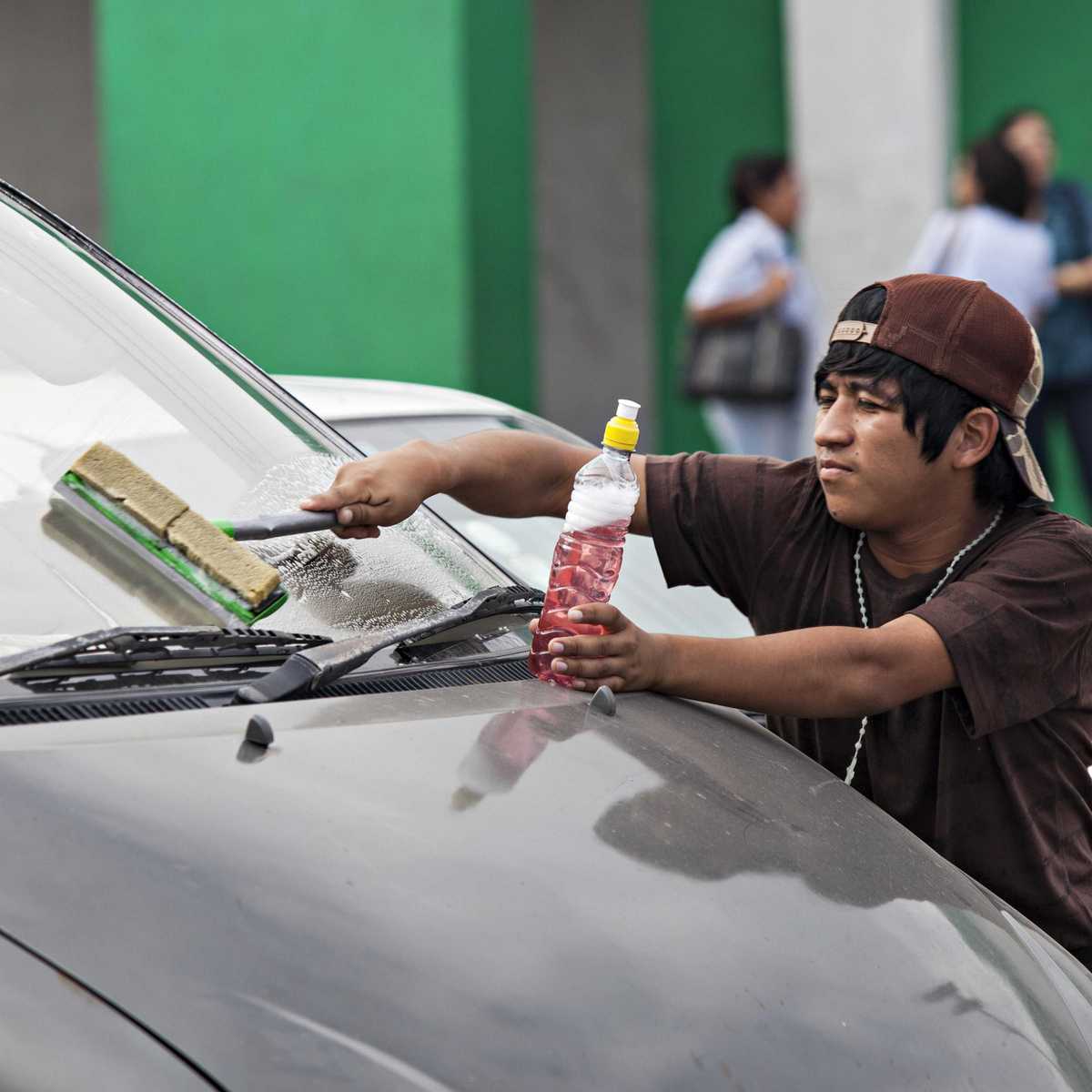 Straßenkind in Bolivien beim Putzen von Autoscheiben