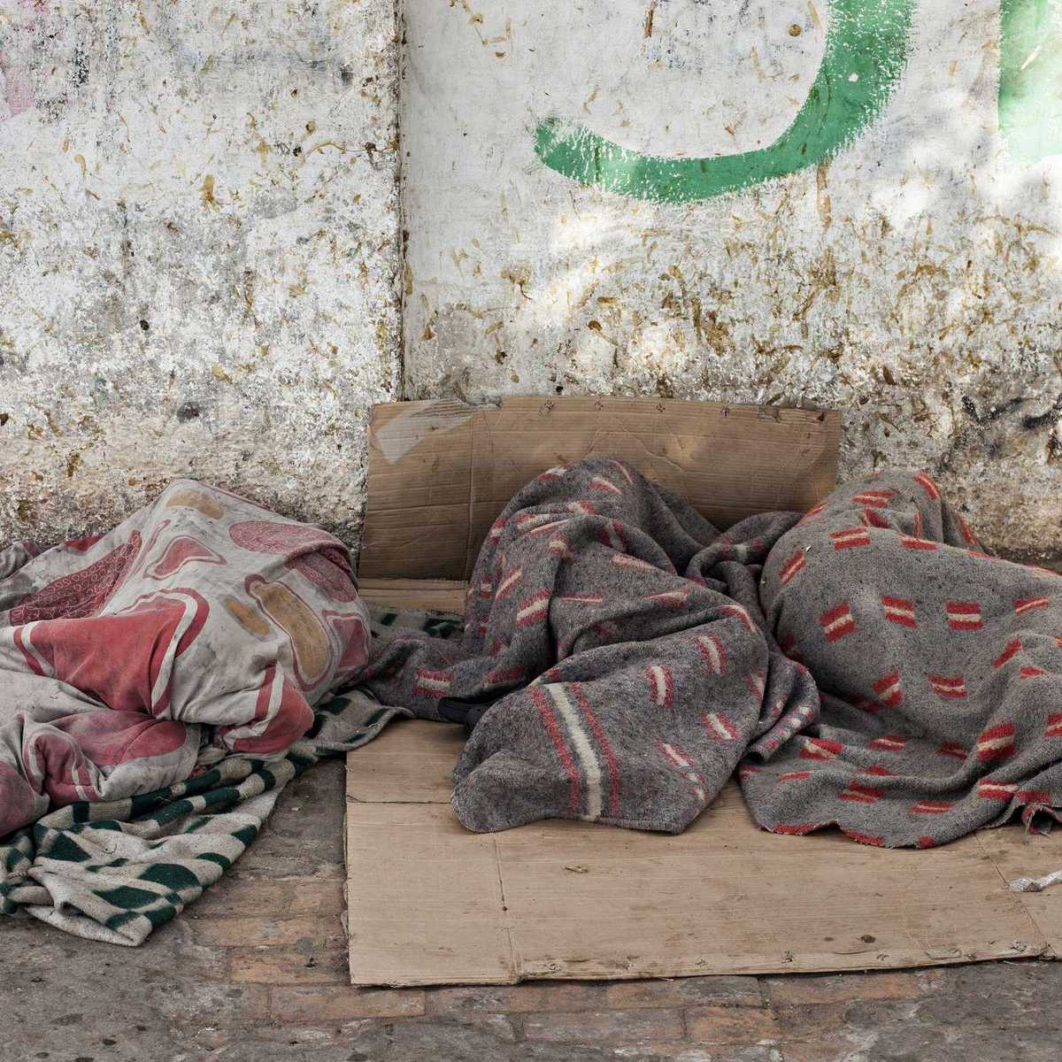 zwei Straßenkinder die auf einem Pappkarton auf der Straße schlafen