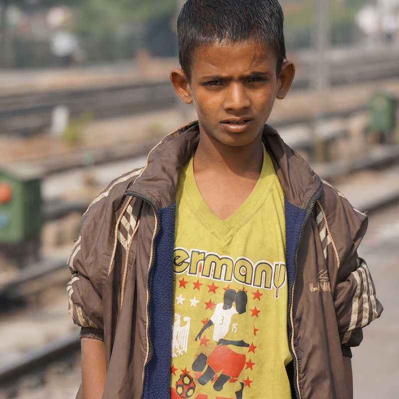 Junge steht an einem verlassenen Bahnsteig