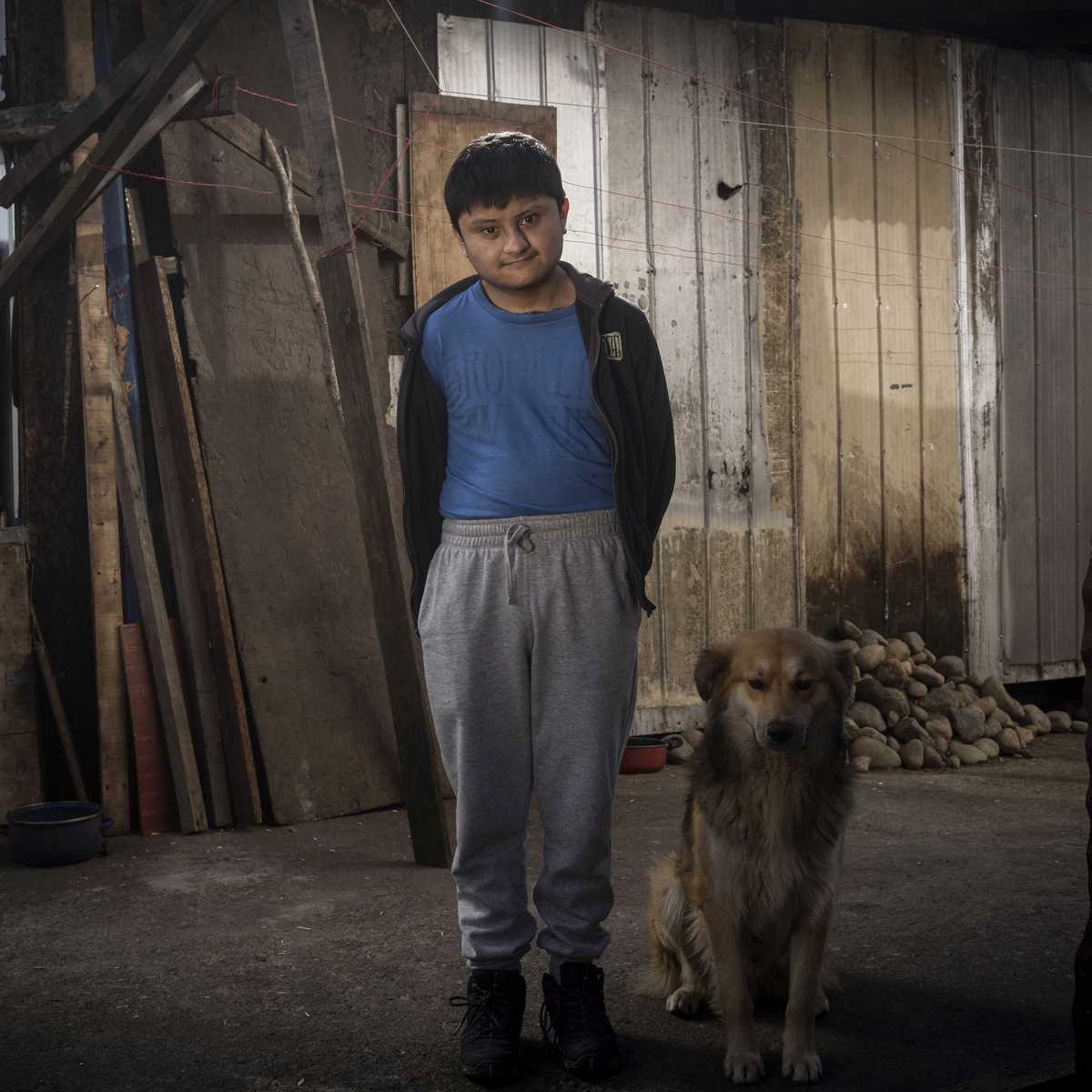 Tomás steht mit seinem Hund vor seiner Hütte