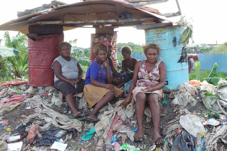 Frauen sitzen auf der Mülldeponie